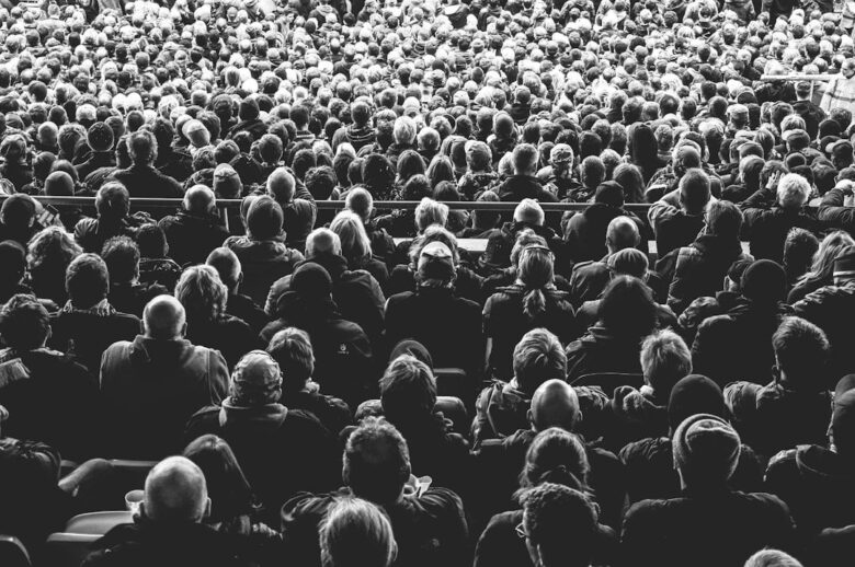 Grote groep theaterbezoekers zit dicht op elkaar in een zaal