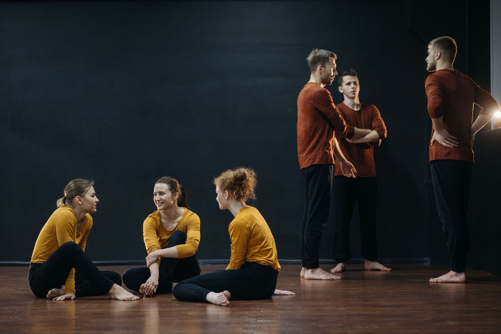 Acteurs bespreken fysiek spel tijdens een theaterrepetitie